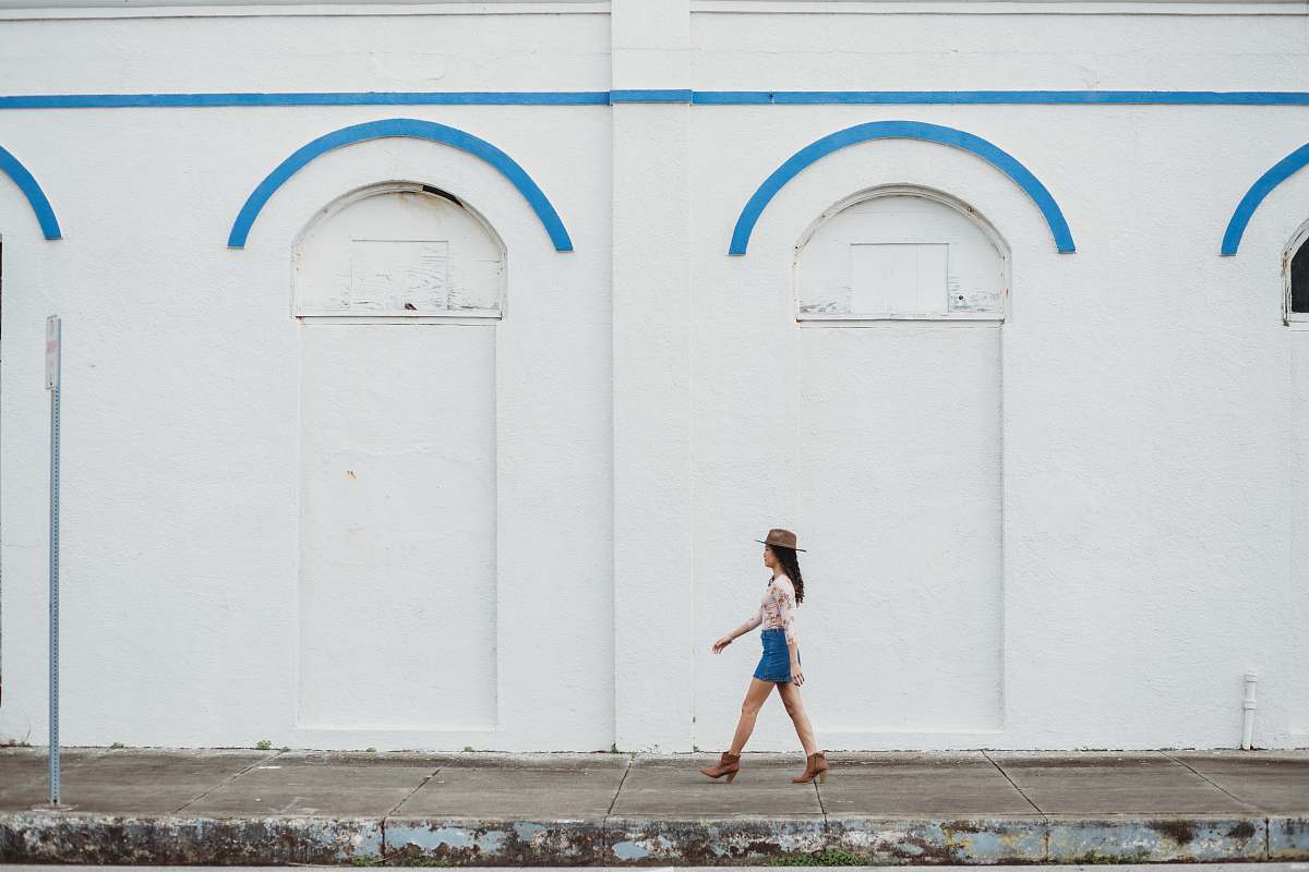 united states woman walking near white concrete building during daytime grey